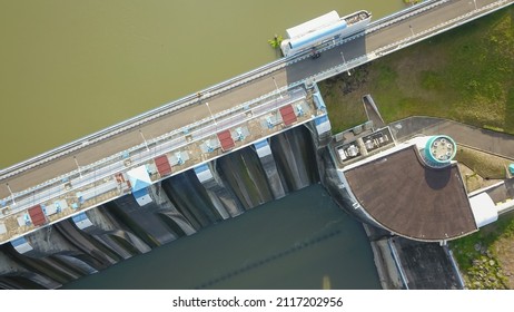 Aerial Top Down Drone Above Bendungan Sampean Baru In Java, Indonesia. Shot Over A Water Dam Reservoir With Asphalt Road Bridge Above Hydroelectric Ecology Renewable Energy With A Concrete Structure