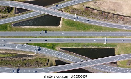 Aerial Top Down Helicopter View Of Modern Road Junction Is Where Two Or More Roads Meet Showing Traffic Flow Moving In Both Way Over The Grade-separated Interchanges