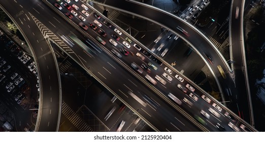 Aerial top down of multilevel elevated road huge traffic junction in modern metropolis city. Night long exposure motion blur of vehicles. Modern development of infrastructure and motorways in China.