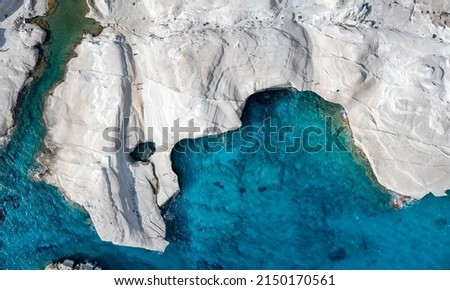 Aerial top down panoramic view of the chalk rock formations of Sarakiniko with sparkling blue sea, Milos island, Cyclades, Greece