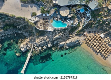 Aerial Top Down Photo Of A Beach Club In Mykonos With Turquoise Water In Greece