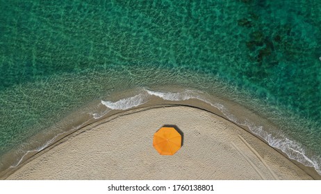 Aerial Top Down Photo Of Beautiful Turquoise Mediterranean Secluded Sandy Bay Forming A Small Peninsula With Only One Colourful Sun Umbrella Enjoying Summer