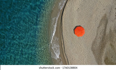 Aerial Top Down Photo Of Beautiful Turquoise Mediterranean Secluded Sandy Bay Forming A Small Peninsula With Only One Colourful Sun Umbrella Enjoying Summer