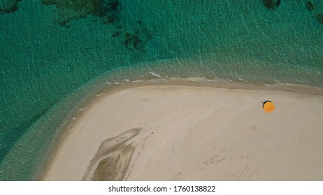 Aerial Top Down Photo Of Beautiful Turquoise Mediterranean Secluded Sandy Bay Forming A Small Peninsula With Only One Colourful Sun Umbrella Enjoying Summer