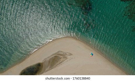 Aerial Top Down Photo Of Beautiful Turquoise Mediterranean Secluded Sandy Bay Forming A Small Peninsula With Only One Colourful Sun Umbrella Enjoying Summer