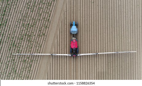 Aerial top down photo of tractor spraying herbicides also commonly known as weedkillers are chemical substances used to control unwanted plants and used before crop is grown on field