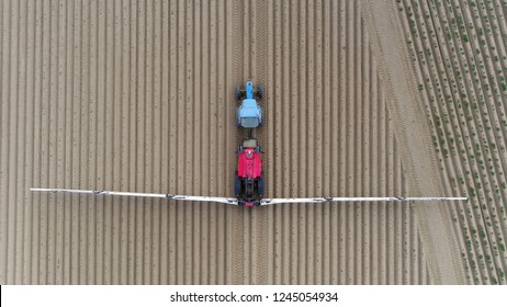 Aerial top down picture of tractor pulling a sprayer is device used to spray liquid commonly used for projection of water weed killers crop performance materials and pest maintenance chemicals