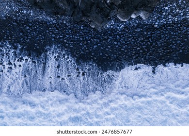 Aerial top down of strong waves of Atlantic ocean reaching rocky stone beach - Powered by Shutterstock