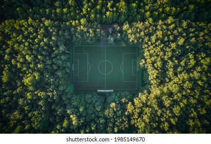 Aerial Top Down View Above The People Playing Football On A Pitch Among The Forest