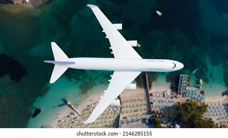 Aerial top down view of an airplane flying over blue sea as a travel concept with copy space