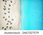 Aerial top down view of a beautiful, tropical beach with colorful umbrellas and turquoise sea, Antigua and Barbuda islands, Caribbean Sea