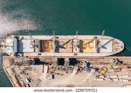 Aerial Top down view Black Sea port Loading of dry cargo ship with ukranian grain by cranes. Maritime grain Import and export concept