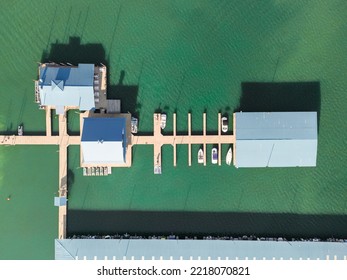 Aerial Top Down View Of Boat Dock And Yacht Port, Boats Are Moored On Sea. Yacht Club Boats Parking. Photo From Drone.