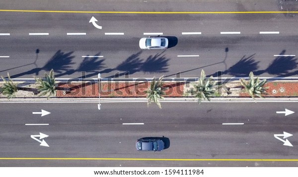 Aerial top down view of cars on\
highway road. High altitude view of cars on the expressway\
street.