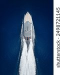 Aerial top down view of a catamaran jet passenger ferry boat traveling with high speed over the ocean