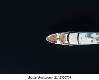Aerial - Top Down View Of Catching Luxury Motor Boat Racing On The Water Large Luxury Yacht Floats In The Sea Port On A Background Of Blue Water Top View Aerial View On Sunset. Travel Summer Vacation