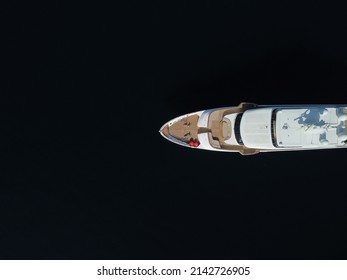 Aerial - Top Down View Of Catching Luxury Motor Boat Racing On The Water Large Luxury Yacht Floats In The Sea Port On A Background Of Blue Water Top View Aerial View On Sunset. Travel Summer Vacation