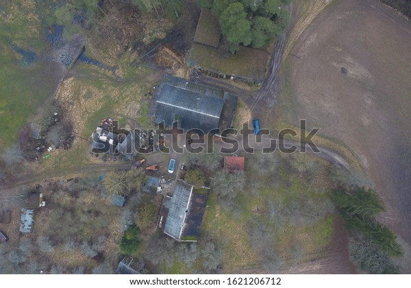 Aerial top down view of countryside\
farmstead house and farm buildings. Autumn\
nature.