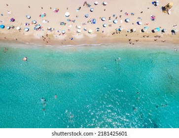 Aerial top down view of a crowded beach with turquoise sea as seen in Athens, Greece, during summer time - Powered by Shutterstock