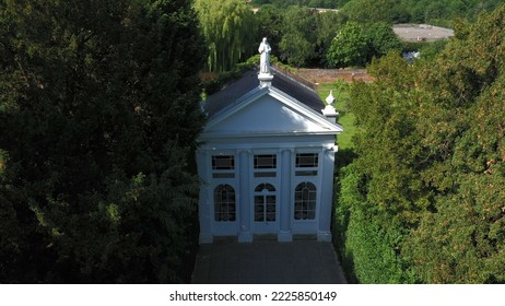 Aerial top down view from the drone onto the narrow passageway leading to a small chapel. Chapel located in a big green open area of fields near Rosary Manor, Mill Hill, North West London, London, UK. - Shutterstock ID 2225850149