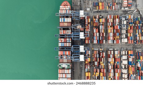 Aerial top down view from drone, crane lift container into the transport ship in commercial port, shipping business and industry service of cargo logistic import and export international freight  - Powered by Shutterstock