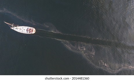 Aerial Top Down View To The Edge Of The Oil Spill Leak Site With Recreational Yacht Make Way To Pass It Safely On The Tallinn City Area In Baltic Sea