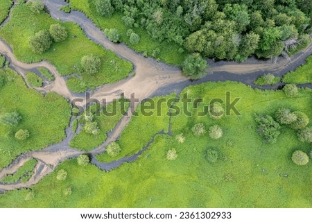 Aerial top down view of a grass lands with a river running through the middle. Photo taken in Michigan in the summertime. 