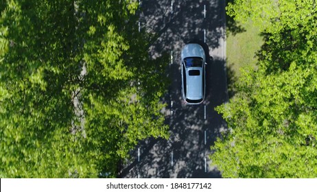 Aerial top down view of grey station wagon vehicle overtaking drone camera driving over straight road testing area for development of self driving electronic automobiles ev's 4k high resolution - Shutterstock ID 1848177142