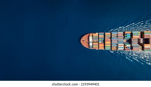 Aerial top down view of a large container cargo ship in motion over open ocean with copy space