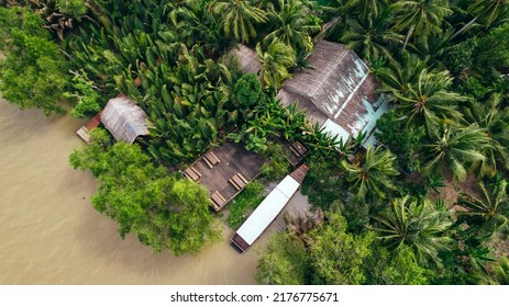 Aerial Top Down View Of Local Home Along Tropical Jungle Of Mekong River In Ben Tre Vietnam With Dock And Boat