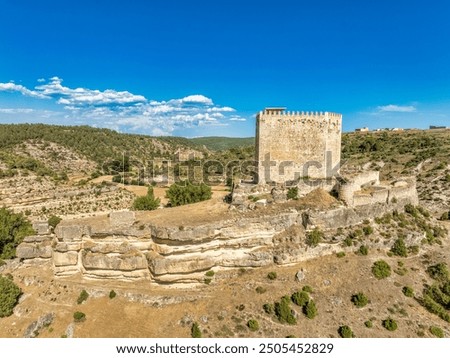 Aerial top down view of medieval Paracuellos de la Vega castle on the rocky hill in a valley in Spain with battlements