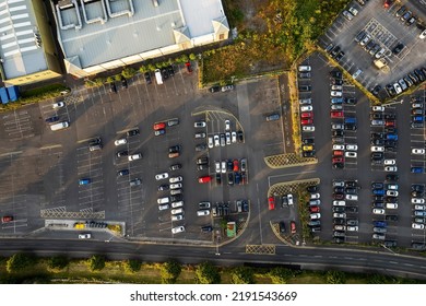 Aerial Top Down View On A Half Full Car Park By A Factory Building Or Shopping Mall. Transportation Industry.