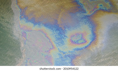 Aerial Top Down View To The Sea Surface With The Rainbow-colored Oil Spill Pattern