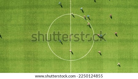 Aerial Top Down View of Soccer Football Field and Two Professional Teams Playing. Passing, Dribbling, Attacking. Football Tournament Match, International Championship. Flyover Whole Stadium Shot.