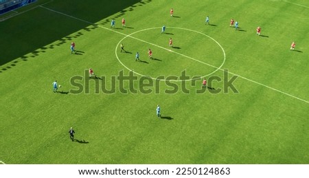 Aerial Top Down View of Soccer Football Field and Two Professional Teams Playing. Passing, Dribbling, Attacking. Football Tournament Match, International Competition. Flyover Whole Stadium Shot.