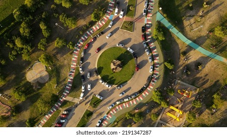 Aerial Top Down View Of Traffic Crossing Intersection And Cars Parked Along Road Side.