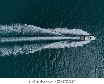 Aerial top down view of white speed motor boat on open sea at summer day - Powered by Shutterstock