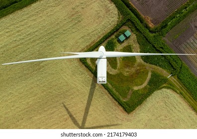 Aerial top down view of a wind turbine in a small rural wind farm in the English countryside - Powered by Shutterstock