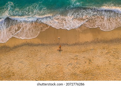 Aerial Top Down View Of Woman Laying On Sandy Beach Of Milos Beach, Lefkada Island, Greece