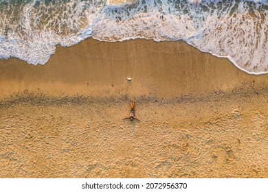 Aerial Top Down View Of Woman Laying On Sandy Beach Of Milos Beach, Lefkada Island, Greece