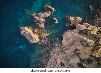 Aerial Top Shot Of Two Paddle Boarders On Beautiful Coastal Feature