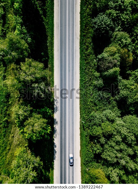 Aerial top view from above of road through the\
green forest in rural\
country