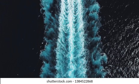 Aerial top view of a beautiful rail on the sea or ocean surface behind of speed cruise liner. Stock. Wake in the ocean made by large ship.