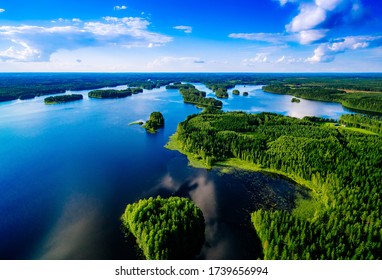 Aerial top view of blue lakes with islands and green forests in Finland. Beautiful summer landscape.