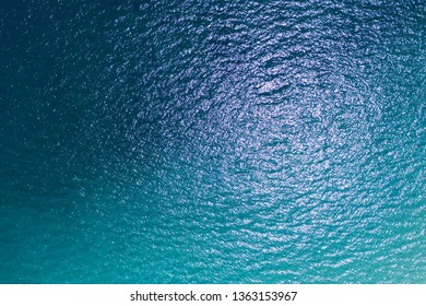 Aerial Top View Of Blue Ocean Surface Background, View From Above Shot By Drone