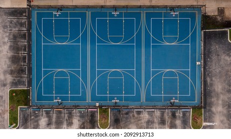 An Aerial, Top View Of A Blue And White Basketball Court In An Empty School Yard In Coral Springs Florida. It Was Shot On A Cloudy Morning With No People Around.