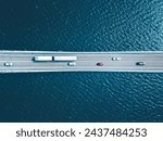 Aerial top view of bridge road with cars over lake or sea in Finland