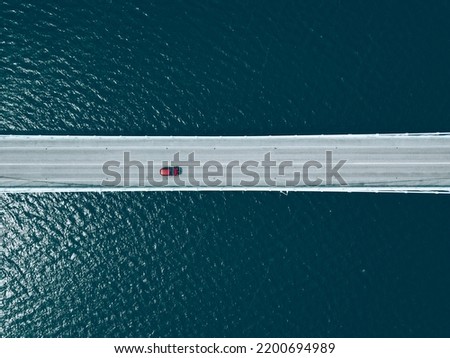 Aerial top view of bridge road with cars over blue lake in summer Finland