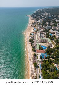 aerial top view of Bulgaria's resort during the summer season: an array of hotels, pools, and crowds of people enjoying the sea. - Shutterstock ID 2340153339