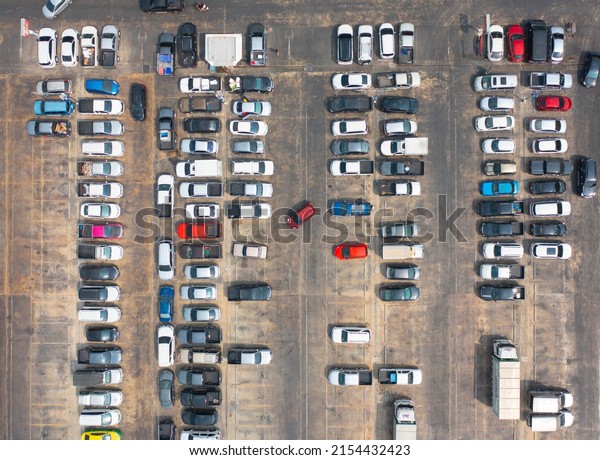 Aerial top view of cars in\
parking lots with street road in urban city. Transportation and\
vehicles